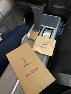 Norse airline amenity packets: earphones and eye mask.