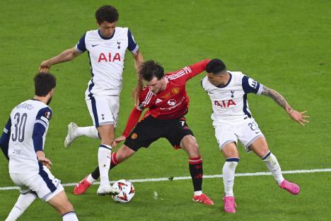 Tottenham and Manchester United players vying for the ball during a soccer match.