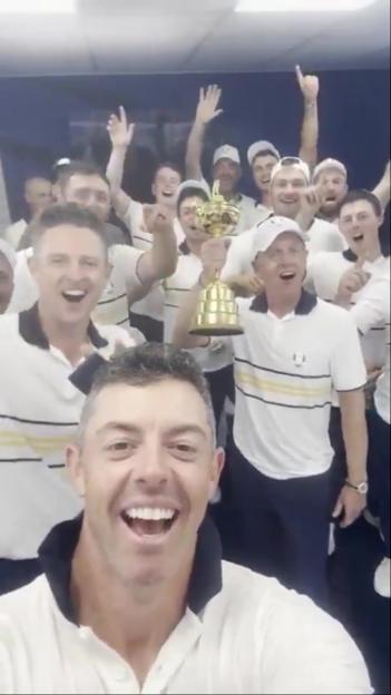 Rory McIlroy takes a selfie with the victorious European Ryder Cup team holding the trophy.