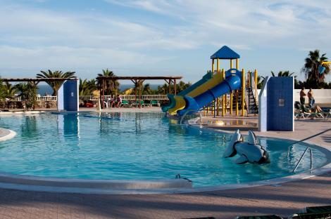 Swimming pool with water slides and inflatable whale.