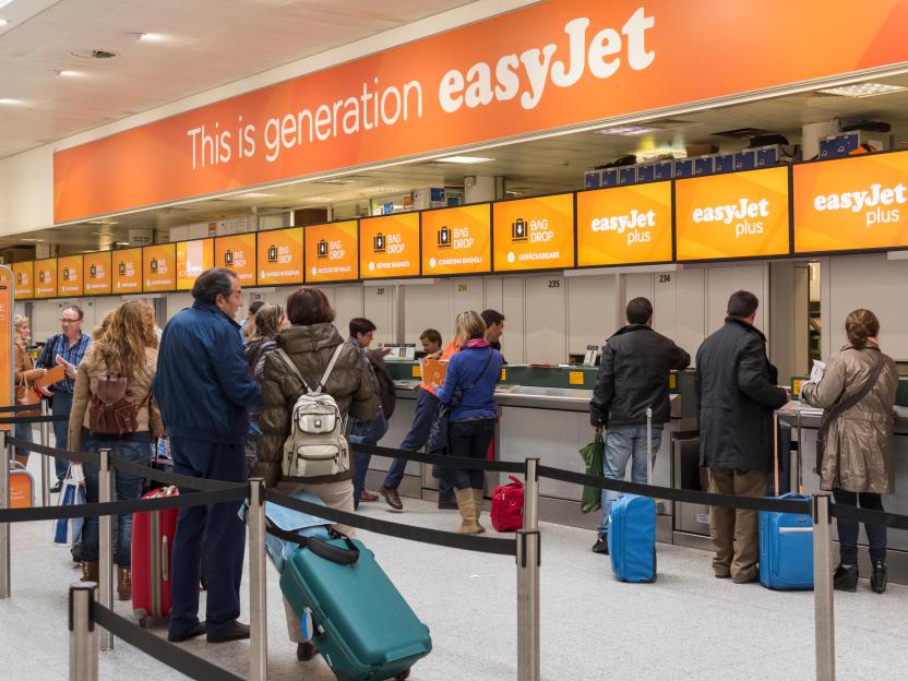 Passengers queuing at an easyJet check-in desk.