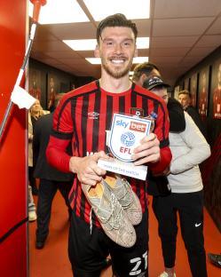 Kieffer Moore of Bournemouth holding his Man of the Match award and soccer cleats.