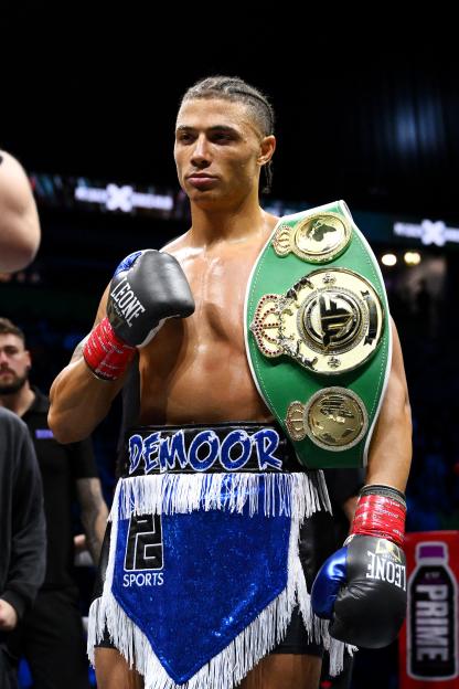 Chase Demoor celebrating a victory with a championship belt.
