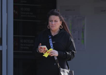 Woman outside courthouse using phone.