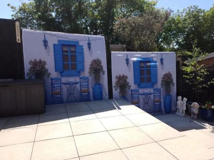 Two garden screens depicting a Greek-style patio scene.