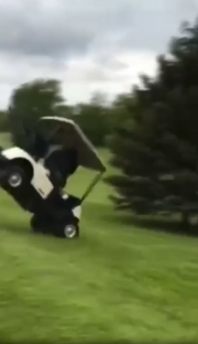Golf cart flipping over on a golf course.