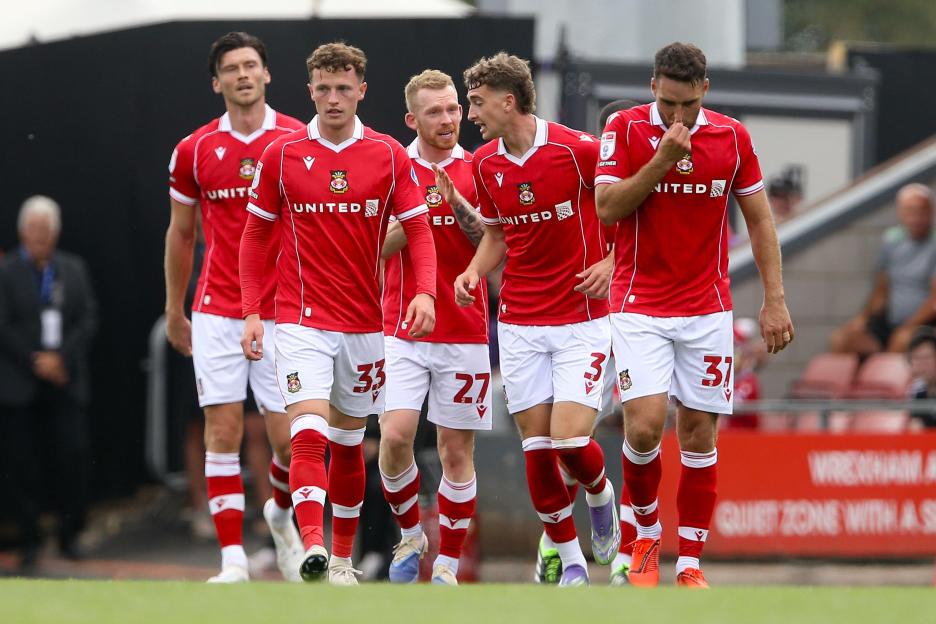 Wrexham soccer players walking on the field.