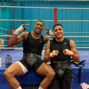 Two boxers posing in a boxing gym.