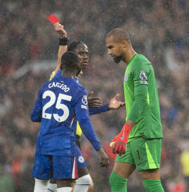 Referee Peter Bankes shows a red card to Robert Sanchez of Chelsea during a soccer match.