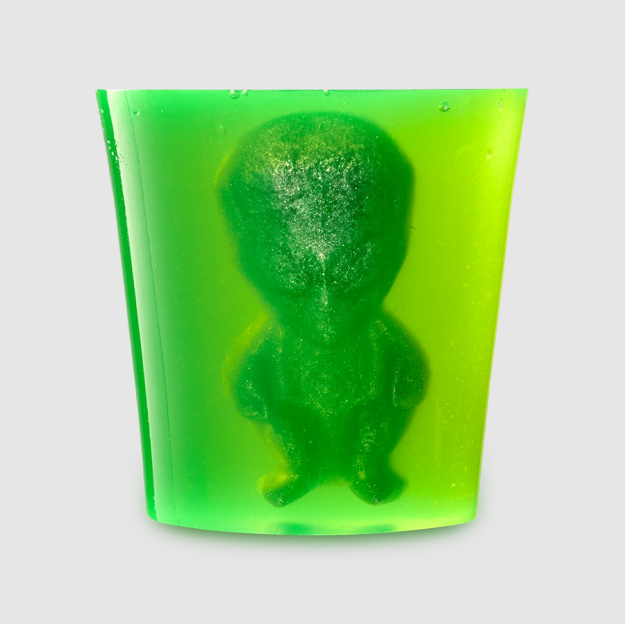 Green jelly in a shot glass with an alien-shaped jelly inside.