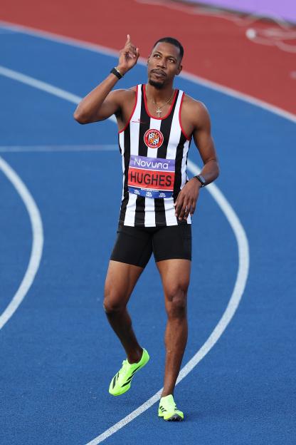 Zharnel Hughes celebrating after winning a 100m race.