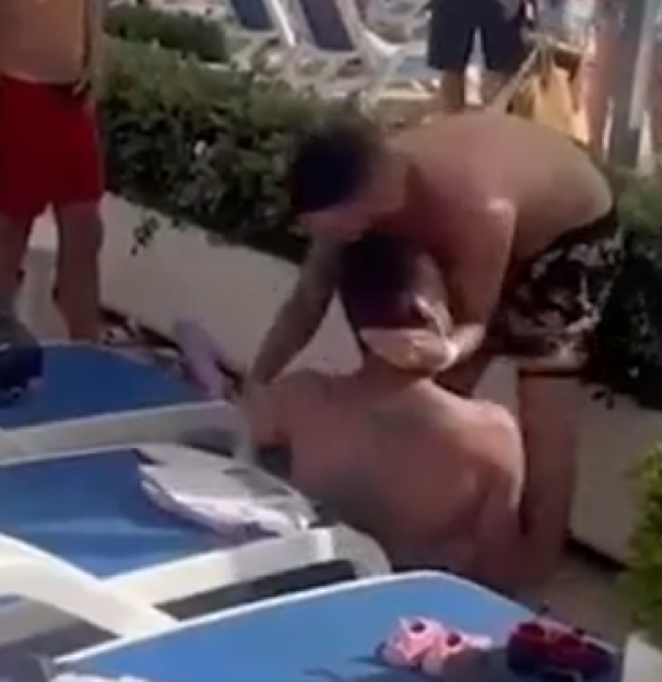 Two men fighting by a poolside.