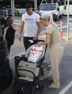 Molly Mae and Tommy Fury arriving at an airport with a stroller and luggage.