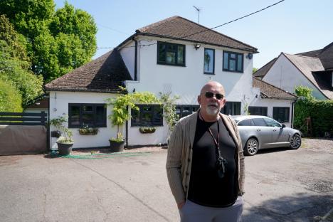 Man standing in front of his house near an HS2 construction site.
