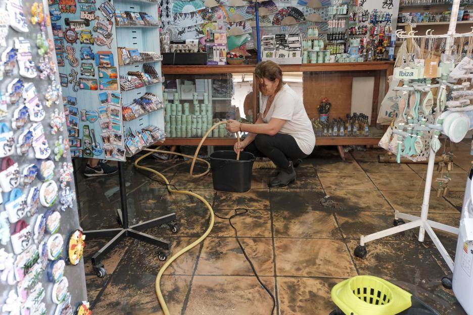 A person cleaning a souvenir shop damaged by floods in Ibiza, Spain.