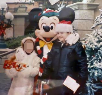 Photo of a young girl at Disneyland with Mickey Mouse.