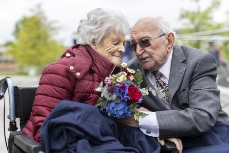 An elderly couple, both RAF veterans, share a kiss on the 80th anniversary of VE Day.