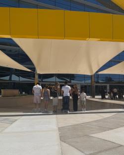 Family standing outdoors under a yellow awning.