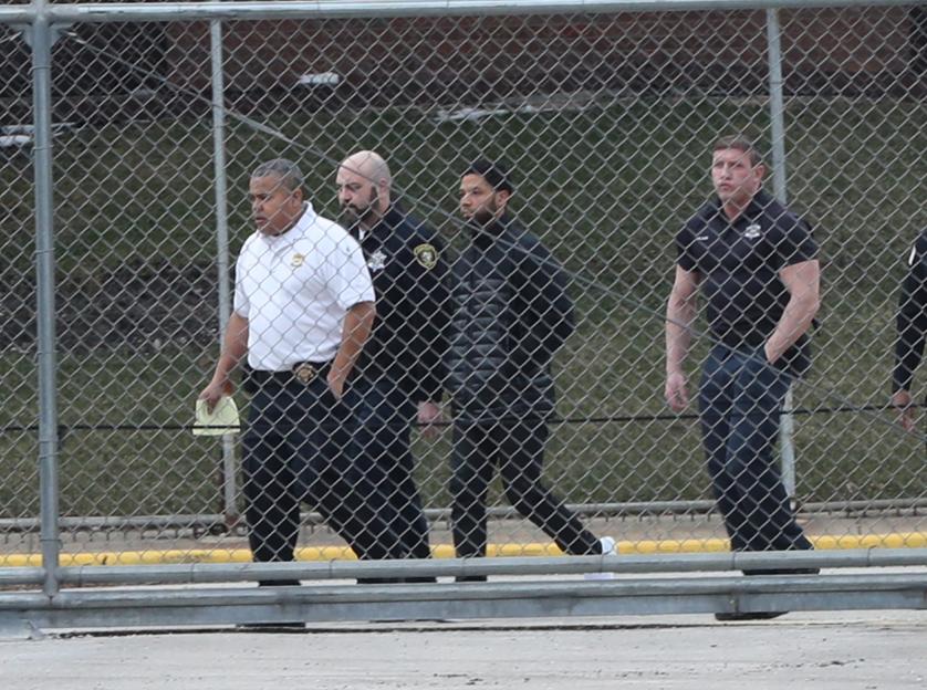 Jussie Smollett leaving Cook County Jail, escorted by bodyguards.