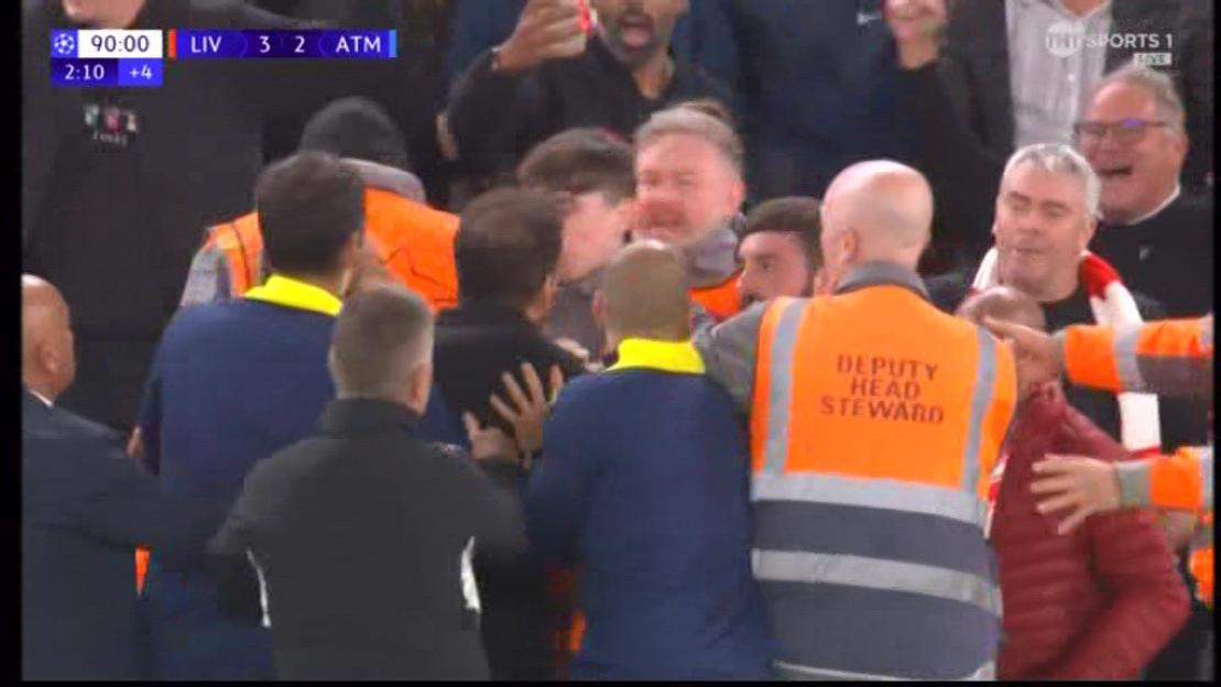 Stewards breaking up an altercation between fans at a soccer match between Liverpool and Atlético Madrid.