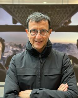 Portrait of a man with glasses and arms crossed.