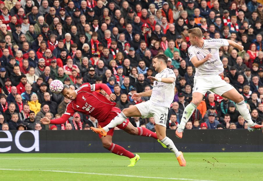 Virgil van Dijk of Liverpool heading the ball against Diogo Dalot of Manchester United.