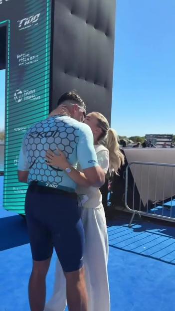 Tommy Fury kissing someone after completing a triathlon.