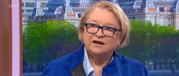 Woman in blue jacket speaking on television.