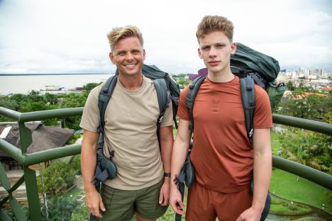 Jeff Brazier and his son Freddy, wearing backpacks, stand on an overlook.