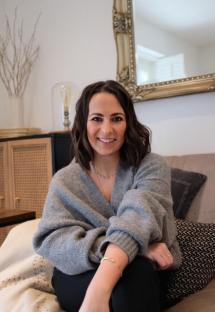 Woman in gray cardigan smiling.