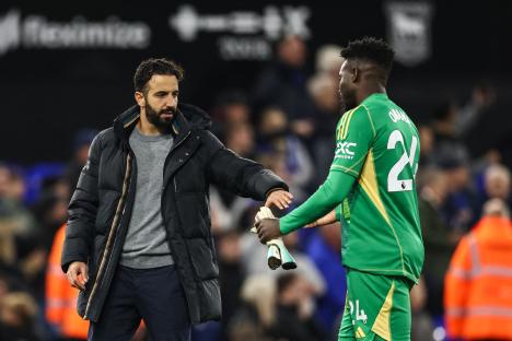Manchester United's coach and goalkeeper shaking hands after a soccer match.