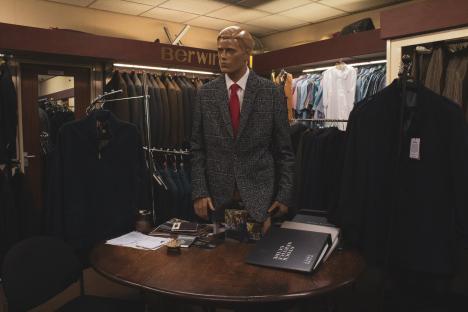 Mannequin in suit jacket and red tie in a tailor shop.