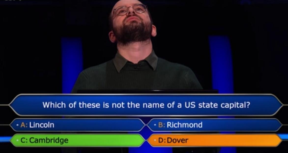 Screenshot of a contestant on Who Wants to Be a Millionaire? considering the question: "Which of these is not the name of a US state capital?" The options are Lincoln, Richmond, Cambridge, and Dover.