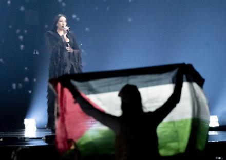 Protestor holding a Palestinian flag during an Israeli singer's Eurovision performance.