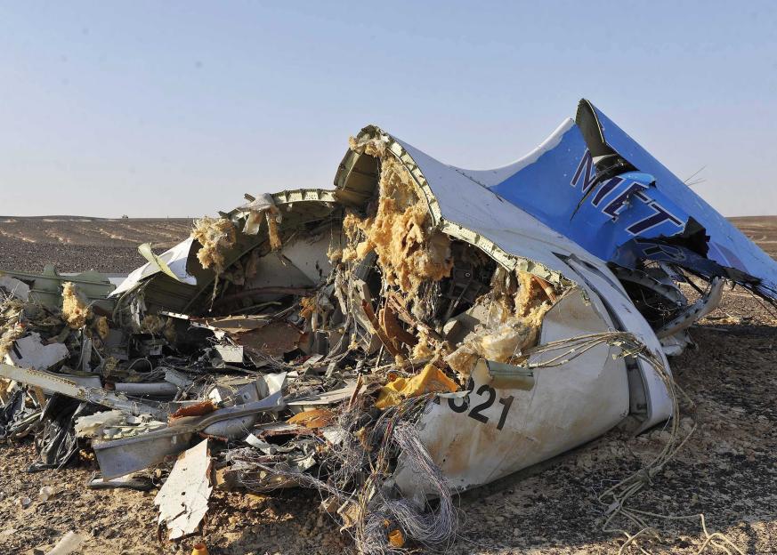 Debris from a crashed Russian jet with visible insulation and wires on the sand.