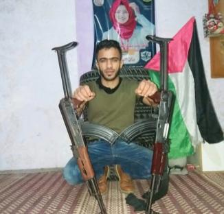 Man posing with two rifles and a Palestinian flag.