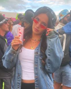 Woman at a festival holding a can of drink.