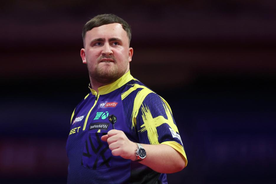 Luke Littler celebrates during a darts match.