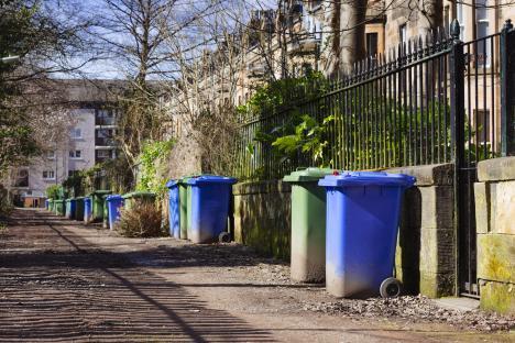 Four recycling bins in a row.