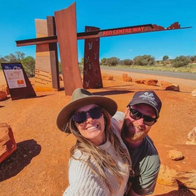 Couple taking a selfie at the Red Centre Way sign.