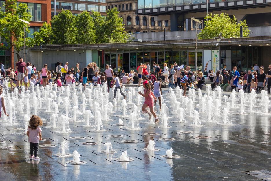 Children playing in a water fountain.