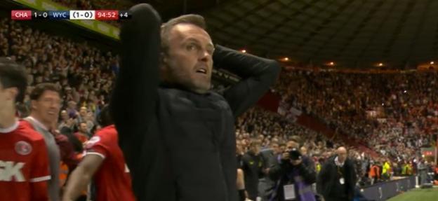 Nathan Jones with his hands behind his head, surrounded by a cheering crowd.