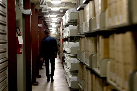 a man walks down a hallway with a fire extinguisher on the wall