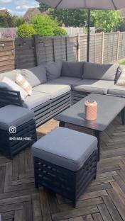Outdoor sectional sofa set with coffee table and ottomans on a patio.