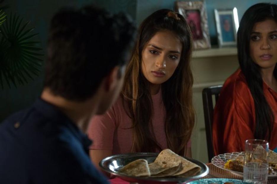 a man and two women are sitting at a table with plates of food .