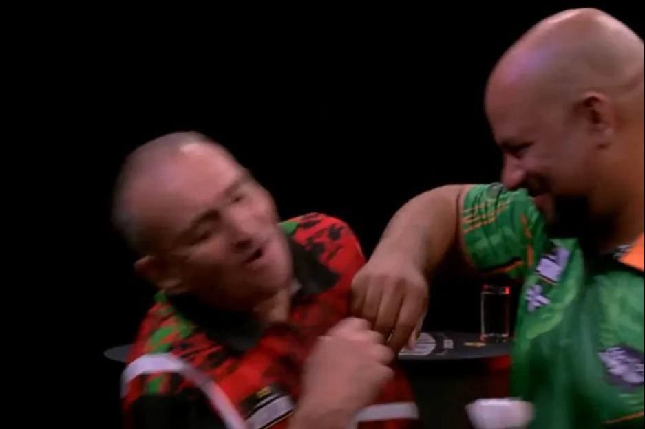 Darts match in bizarre ending as star pretends to PUNCH rival… before awkwardly injuring himself on live TV