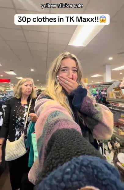 Woman excitedly shows off 30p clothes found at TK Maxx's yellow sticker sale.