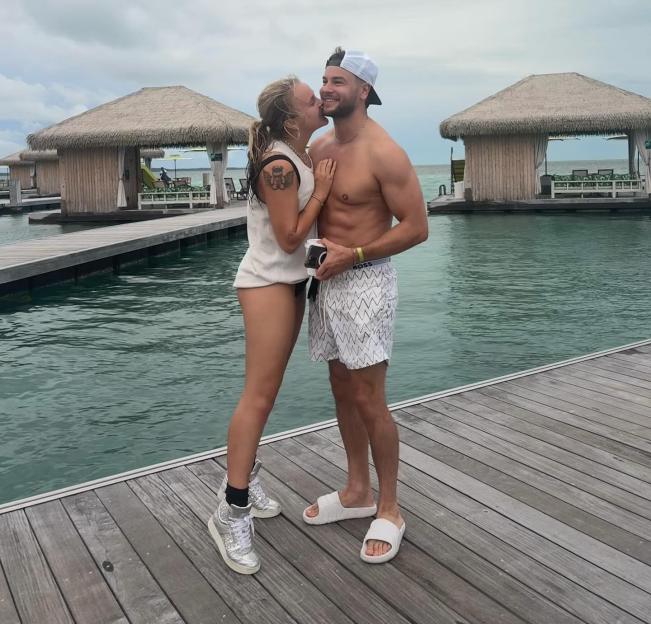 Jojo Siwa and Chris kissing on a dock.