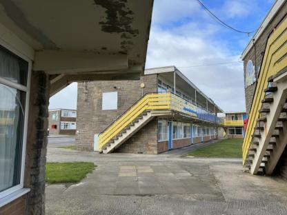 Exterior view of an abandoned holiday park building.