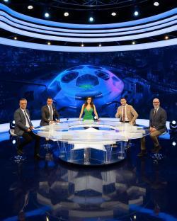 Four sportscasters sitting around a table in a television studio.